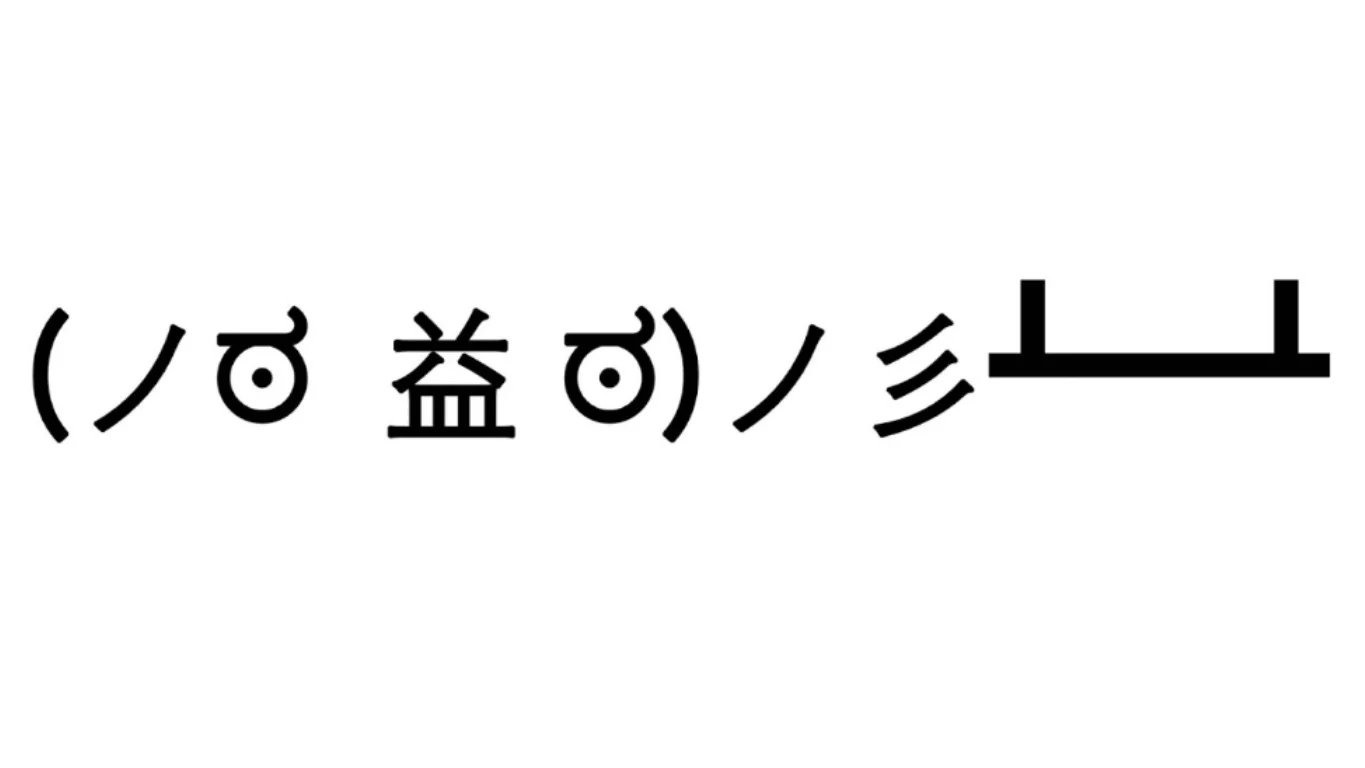 Un emoticono de texto negro volteando una mesa sobre fondo blanco.