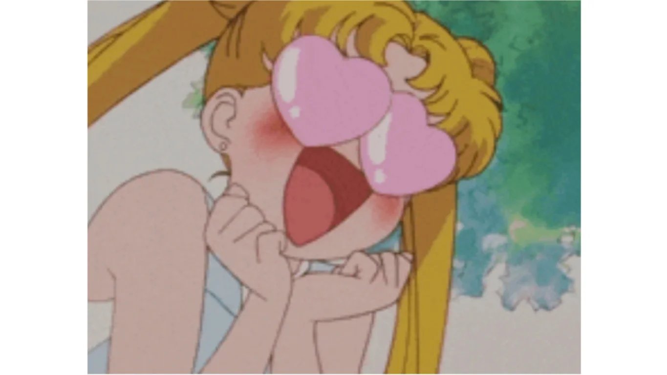 Un personaje estilo anime con grandes ojos rosas en forma de corazón, las manos juntas y la boca abierta.